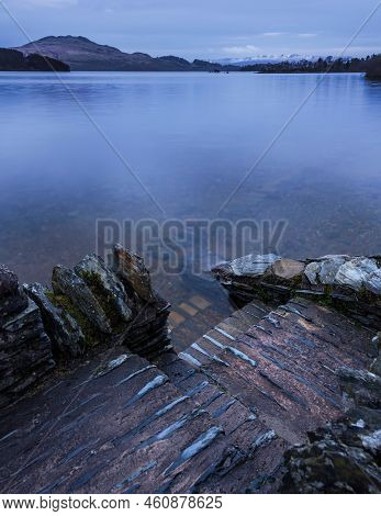 Stunning Landscape Image Of Loch Lomond And Snowcapped Mountain Range In Distance Viewed From Small 