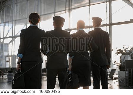 Flight Team Standing In The Airport In Front Of The Panoramic Window