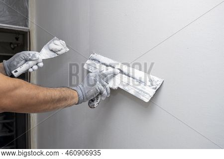 Plasterer Applies Plaster On The Wall During Repair And Restoration Work. Leveling The Wall With A S