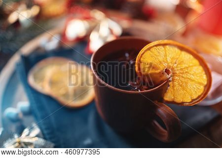 Mulled Red Wine Gluhwine In Cup With Orange, Christmas Decor Table With Candles