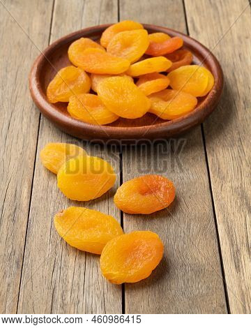 Dried Apricots In A Plate Over Wooden Table.