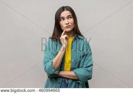 Portrait Of Pensive Woman With Dark Hair Thinking, Looking Away, Having Puzzled Confused Facial Expr