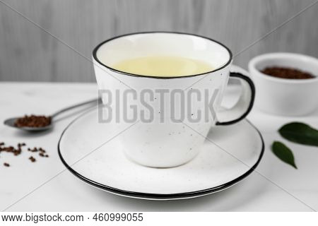 Cup Of Buckwheat Tea On White Marble Table, Closeup