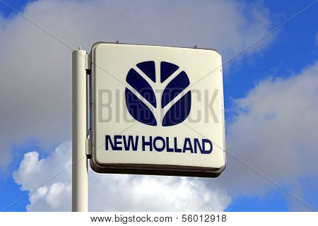 New Holland Sign Against Blue Sky With Some Clouds