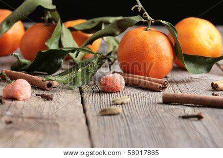 Fresh Mandarin Oranges And Cinnamon On Wooden Table