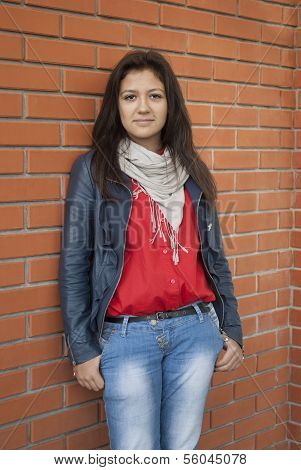 junges MÃ¤dchen steht auf einem Hintergrund eine Mauer.