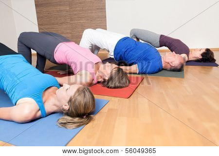 An image of some people doing yoga exercises - Setu Bandha Sarvangasana 