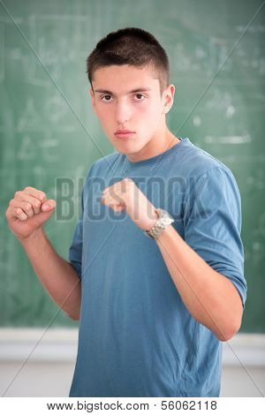 Highschool student in boxing stance in schoolroom