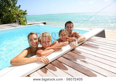 Happy family enjoying bath time in infinity pool
