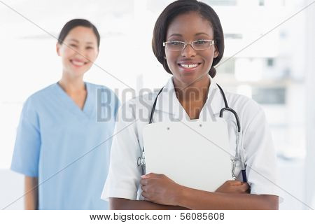 Portrait of a confident female doctor and surgeon with report in the bright hospital