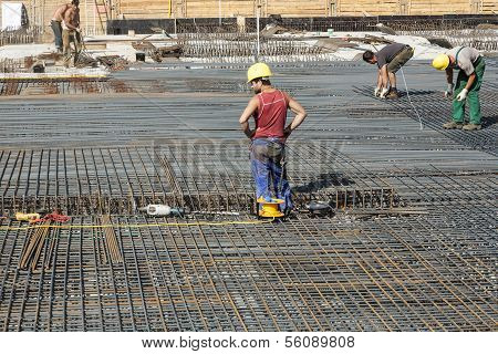 Workers Do The Steel Bars Construction At The Building Site