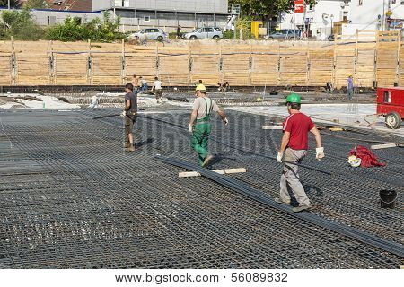Workers Do The Steel Bars Construction At The Building Site