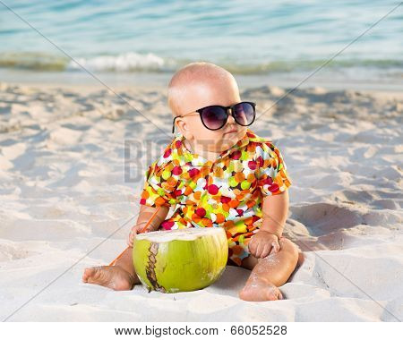 Funny baby wearing sunglasses with coconut