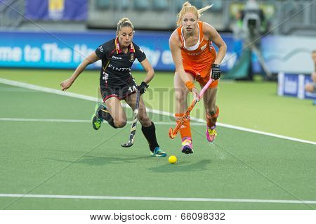THE HAGUE, NETHERLANDS - JUNE 2 2014: Dutch Player Van Geffen (right), rushes past Belgium defender Sinia at the Rabobank World Cup Hockey. NED beats BEL 4-0