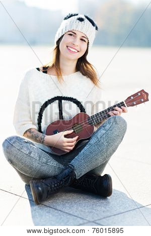 Young woman playing ukulele 
