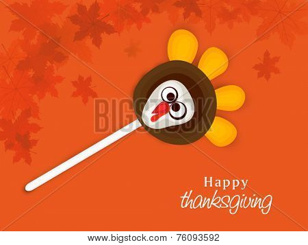 Thanksgiving Day celebration with turkey lollipop on maple leaves decorated orange background.