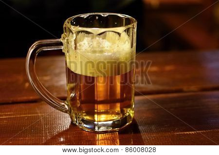 Draft beer by the glass. Honest Czech lager on an old wooden table.