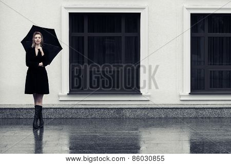 Happy fashion woman with umbrella in the rain