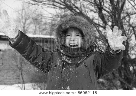 Preschool Girl Is Playing With Snow Outside In A Winter Day