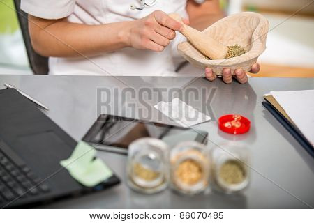 Woman doctor using a mortar and pestle