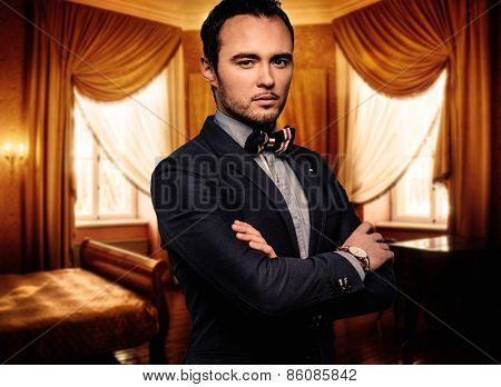 Sharp dressed dandy fashionist in luxury apartment interior 