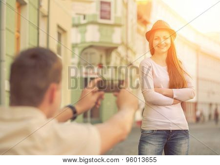 Touristic couple shooting on the modile phone at the city streets under sunlight.