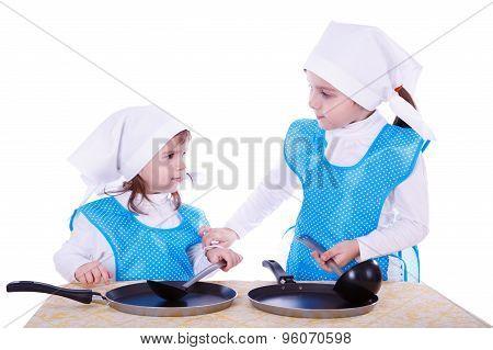 Ittle Children With Pans. Two Cute Girls Playing As Chefs. Isolated On A White Background.