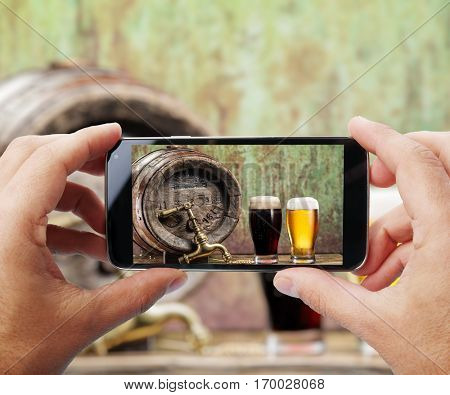 Taking photo of glasses of beer by smartphone.  Closeup view of  process. File contains clipping paths for smartphone and hands and  picture on it.