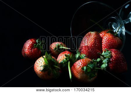 strawberry in glass on black background isolated