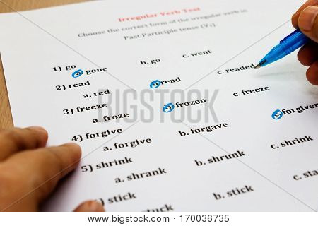 multiple choice english exam with hand on table