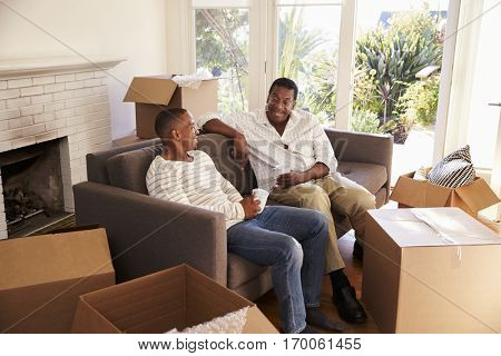 Father And Adult Son Take A Break With Pizza On Moving Day