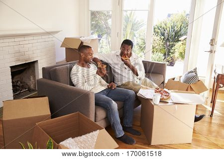 Father And Adult Son Take A Break With Pizza On Moving Day
