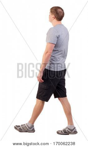 Back view of walking handsome man in shorts and sneakers.   Sports-dressed young man moves. backside view of person.  Isolated over white background. sportsman in summer clothes are left