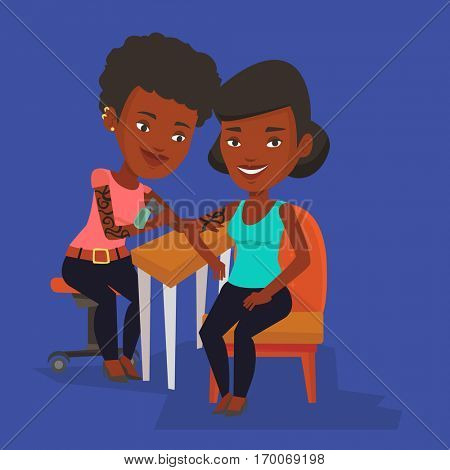 An african-american female tattooist makes a tattoo on the hand of a woman. Tattooist makes a tattoo to a client. Professional tattoo artist at work. Vector flat design illustration. Square layout.