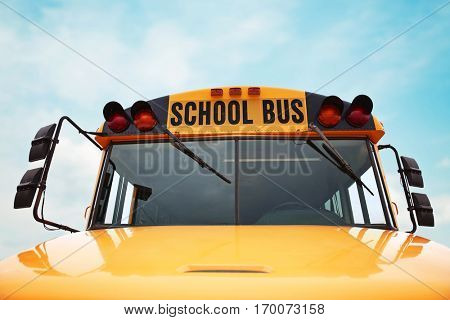  wide angle front view of a bright yellow orange school bus on a sunny summer day with clouds in the sky toned with a retro vintage instagram filter app or action effect 
