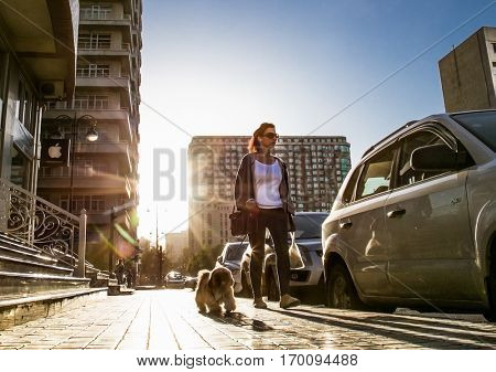BAKU, AZERBEIJAN- OCT 5, 2016: Girl with a dog walking at the street in Baku city on Oct 5, 2016, Azerbeijan.
