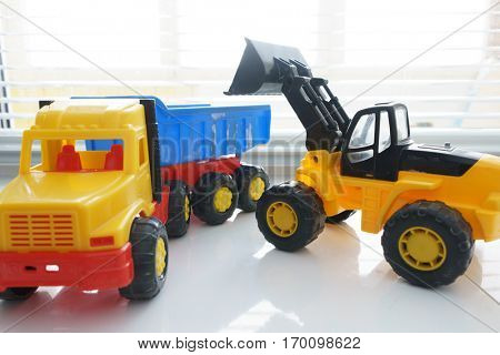Toy Wheel Loader and Toy Dump Truck Close up, Toy Industrial Vehicle, Plastic Wheel Loader Excavator for Earth Moving Works at Construction Site, Miniature Earth Mover, Backhoe Loader