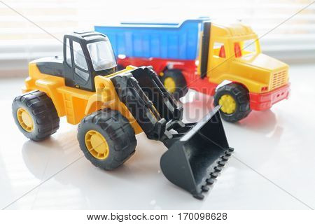 Toy Wheel Loader and Toy Dump Truck Close up, Toy Industrial Vehicle, Plastic Wheel Loader Excavator for Earth Moving Works at Construction Site, Miniature Earth Mover, Backhoe Loader