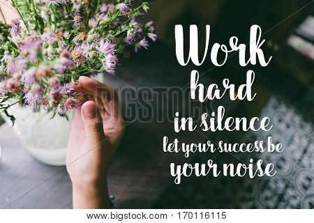Life quote. Motivation quote on soft background. The hand touching purple flowers. Work hard in silence let your success be your noise.