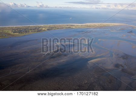aerial view of the mudflat coastline at low tide with water winding in the mud and sand bank Frisian island Ameland The Netherlands