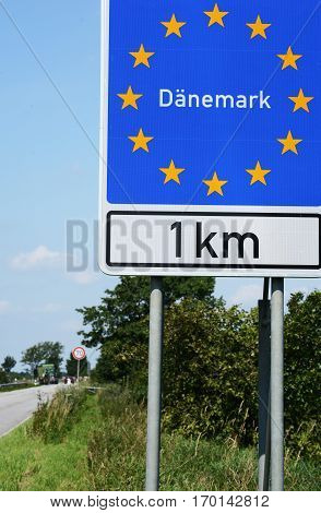 Photo with Danish border sign by the road.