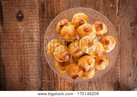 Group of sweet cream puffs on glass tray.