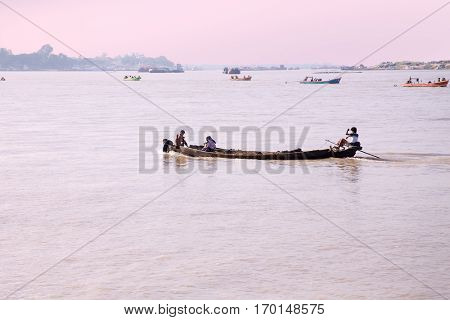 IRRAWADY RIVER, MYANMAR - November 17, 2015: Boats on the Irrawaddy River at sunrise. The Irrawady river  is a river that flows from north to south through Myanmar and is the most important waterway