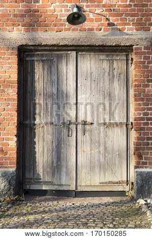 red brick wall and wooden door with vintage lamp