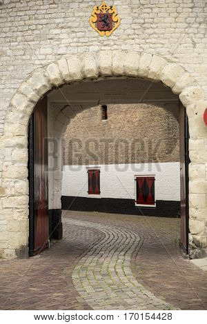 Old city gateway with small cobble stone alley and brick buildingZierikzee the Netherlands