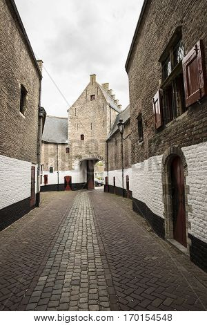 Old city gateway with small cobble stone alley and brick buildingZierikzee the Netherlands