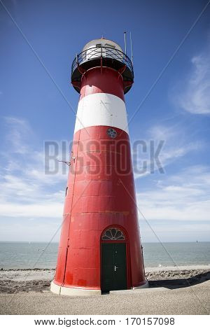 Red and white lighthouse on a blue sky background Westkapelle The Netherlands