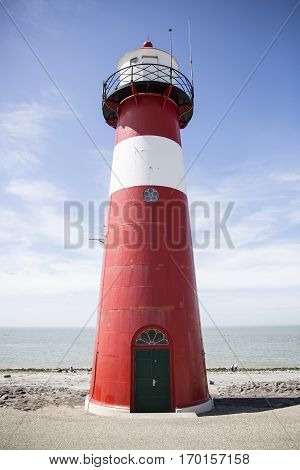 Red and white lighthouse on a blue sky background Westkapelle The Netherlands