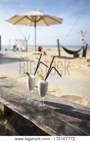 Cocktail glass with two straws and with beach landscape background