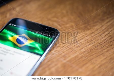 Smartphone On Wooden Background With 5G Network Sign 25 Per Cent Charge And Brazil Flag On The Scree